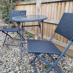 Two chairs and glass top table with some signs from previous plants pots placed on top (unsure if able to scrub them off).

Grey and black, good resistance to weather conditions!
Table measures approx 59x59 for reference.

Collection only from CR4