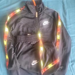 Good condition. Got plenty more wear left. boys age 4-5 black tracksuit with yellow orange red