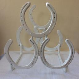 Handmade wine rack made from reclaimed authentic horseshoes. Using 6 horseshoes to make a tiered wine rack that will hold up to 3 bottles. Professionally powder coated in a White satin finish.

Approx 29 cm H x 28cm W x 19cm D

Bottle not included.

Great item as a gift for a horse fanatic or quirky item for your own home decor.

Price includes free postal delivery