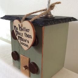 Handmade wooden house / cottage ornament made from reclaimed wood.

Using pieces of reclaimed wood that has been used to make a cottage , it shows markings of original markings / grooves/ usage. It is of a raw appearance.

It has a slate roof and a small metal engine valve and a nail used for the chimney. It has a love heart tag attached with the words .....
“ No better place than mums house”

Approx 13cm H x 10cm W

Price includes free postal delivery