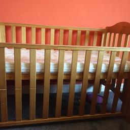 wooden cot with mattres with bars that rise