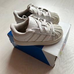 A pair of white Adidas Superstar infant trainers

Size UK 6K