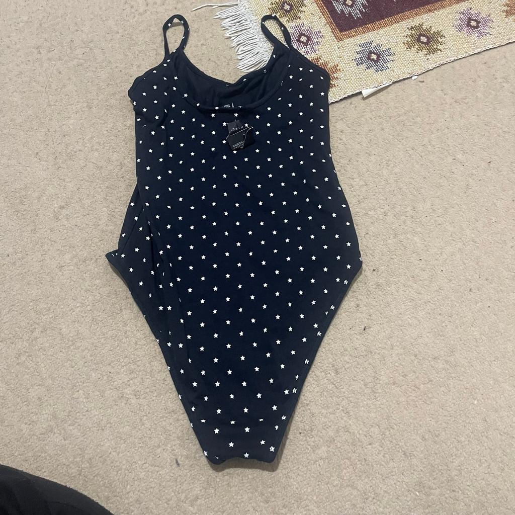 Brand new white and navy swimming costumes. White with a halter neck and navy with press on button with mini stars scattered. 2 for £7
