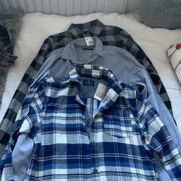 3 long sleeved shirts. Grey & black checked new with tag, age 12-13. Plain blue from next, age 12. Blue checked from next, again new with tag, age 12.