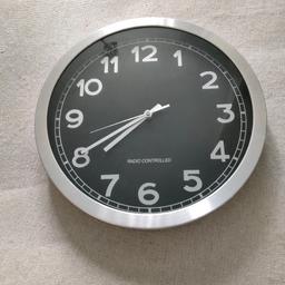 Black background with silver/metal frame.

Excellent condition. There are no dents, no cracks, no chips and no holes anywhere on the clock face. This was bought brand new.