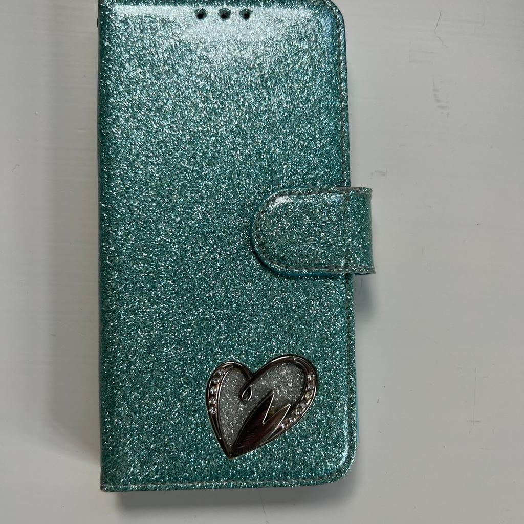 IPhone X (10) case in a Turquoise glitter finish with heart on the front. Magnetic clasp . Protect your phone from damage.Takes a picture and 3 Credit/Debit Cards