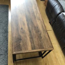 Large oblong coffee table, has a smaller table at each end which slides underneath. The legs are black metal