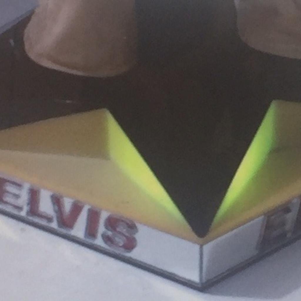This is EXTREMELY RARE and ALMOST IMPOSSIBLE TO FIND IN THE UK as was never released here

The Doll itself is just over 50cms and stands on a base unit with speaker.

In the side compartment there is a tiny cassette tape (see pics) and when that this placed into the side of the base unit Elvis sings Hound dog and the stage flashes different colours (see pics). There is no volume control and plays song quietly.

Also the Guitar has a button that when pressed Elvis sings Blue Christmas and lights up (see pics).

Released in the very early 80s this over 40 years old so as you would expect there is some wear and some marks on the costume, however for its age it is in EXCELLENT CONDITION.
