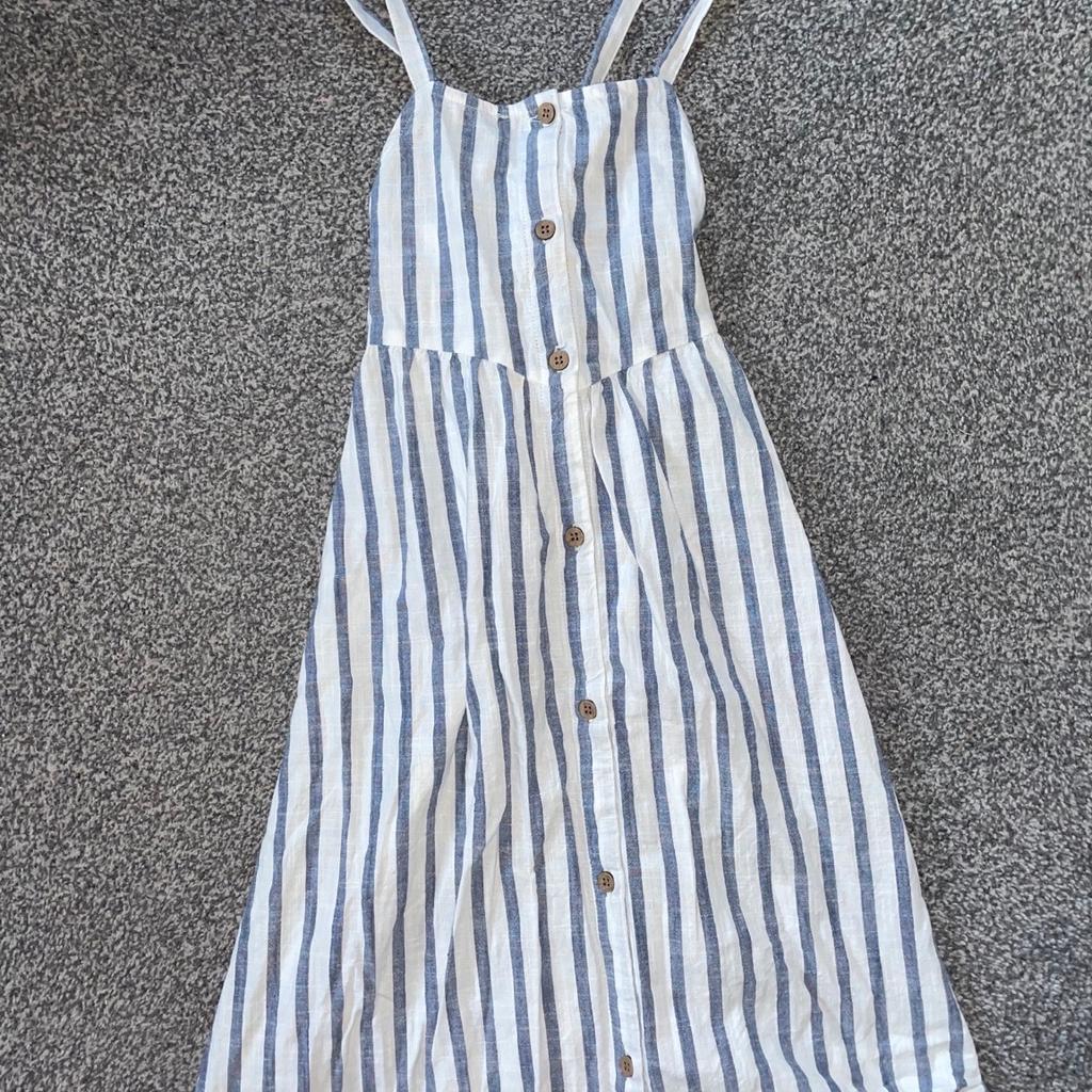 Brand new without tags! Never got chance to wear it. Striped white and blue cotton dress. Beautiful. Crosses at the back age 8