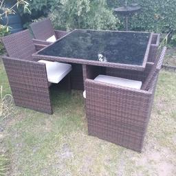 Brown rattan cube set, glastop table, 4 chairs and cream cushions. Can deliver local for fuel.