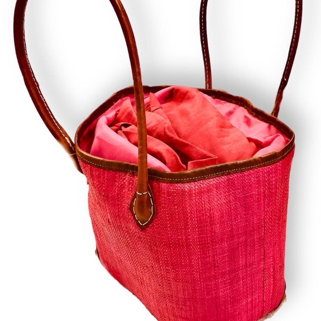 Raffia Magenta Medium Tote Bag with Leather Handles
Looking for a unique and gorgeous everyday tote? This vibrantly colorful and practical luxurious Tote bag has been handwoven from high-quality 100% raffia palm and dyed a vibrant magenta with eco-friendly dyes.
Besides being crafted in super lightweight material, this durable bag features a Tote style, a breezy woven style, reinforced vegan leather corner protectors for an extra chic touch, vegan brown leather handles just long enough to go over the shoulder, open top with a coordinating polyester cloth drawstring top closure, a raffia inner pocket sewn in, and a modern, structured shape.
A fun and fabulous bag to be your ideal companion for work or play due to its generous compartment. Easily accommodates laptops and work documents etc or useful for shopping in the city center or can perfectly fit a beach towel and other sunny day essentials.
It's the go-to tote bag of the summer!
This bag is handmade which makes it chic and un
