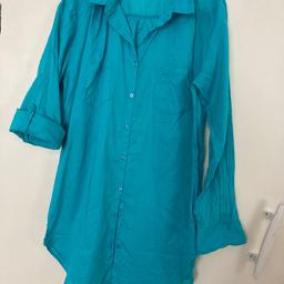 Turquoise blue long length shirt/blouse with two front pockets. Sleeves can be worn long or have button option for shorter length. Rounded hemline. If you require postage please ask first using the question option. Thanks very much.
