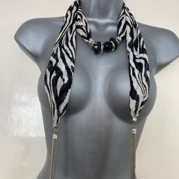 Animal print wrap around necklace with black/silver coloured detail at neck and silver coloured tassels at ends.