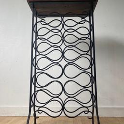 A nicely styled, wrought iron, 22 bottle, wine rack.
With Hardwood top.
In very solid, sturdy condition.
Measuring: 48.5cm wide, 23cm deep, 87.5cm high.
