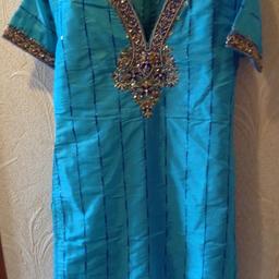 Turquoise & Royal Blue Asian 3 piece Suit decorated with beads, sequins & gems.
In Size Small, as a guide to fit average Size 6 to 10.
From East Meets West.

Top lined, short sleeves & zip back.
Length 34.5 inches,
Width across Bust 34 inches.

Trousers elasticated, lined and decorated at ankle.
Waist (22-30) inches,
Length from waist band 40 inches.

Matching Gold trimmed split coloured Scarf.

In excellent condition worn once, has been dry cleaned.
From smoke free home.