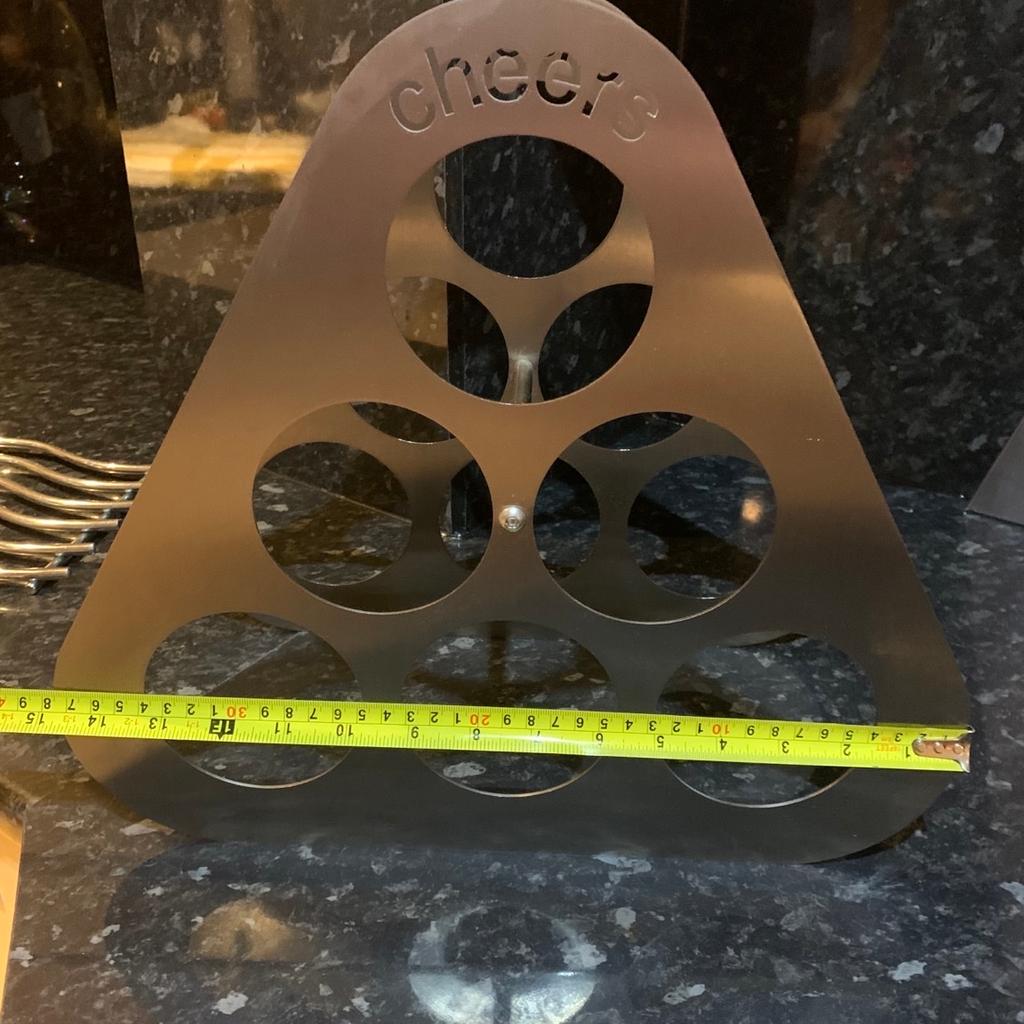 Brushed stainless steel wine rack . Cheers cut out motif at the top. Holds 6 bottles of wine. Looks fab on a kitchen worktop. 38cm wide and 34 cm high. Pick up only. No time wasters or scammers