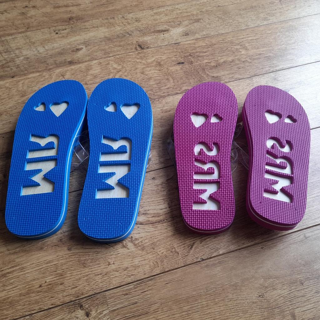 BRAND NEW IN PACKAGING!

Mr & Mrs flip-flops.
Size UK 8-12

One pink pair and one blue pair.

Perfect wedding gift.

Leaves an imprint when walking on sand/beach with Mr/Mrs with love hearts (see last image)

Collection from Marske.

Please check out my other items for sale. Having a clear out.