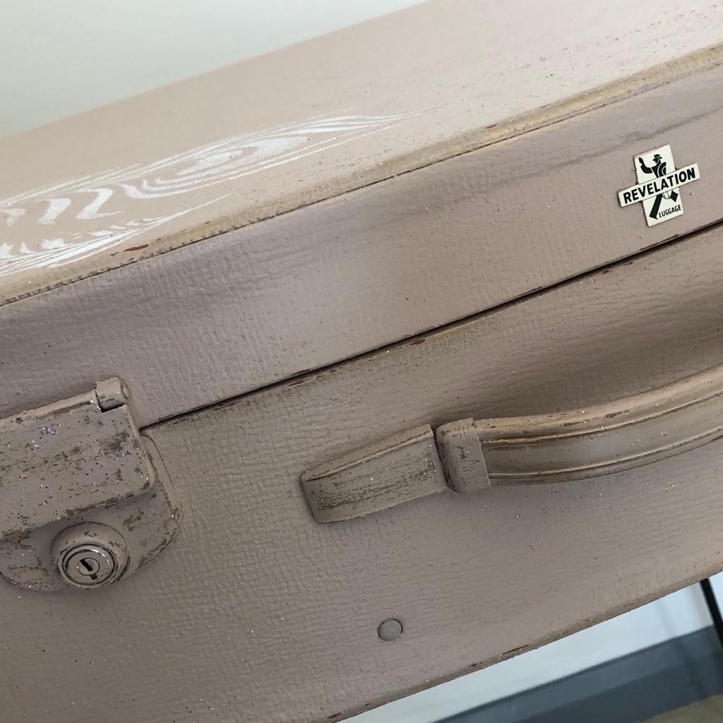 Upcycled vintage suitcase on tall hairpin legs. The legs are superior quality ones.
Painted in Frenchic quality chalk paint, lightly distressed with added feather detail. Glitter detail in the paint so it sparkles in the dark.
NB-being a vintage suitcase, one of the latches does not work 100% but isn’t really a problem just wanted to mention it.
Dimensions 89cms H 61cms W 47cms D