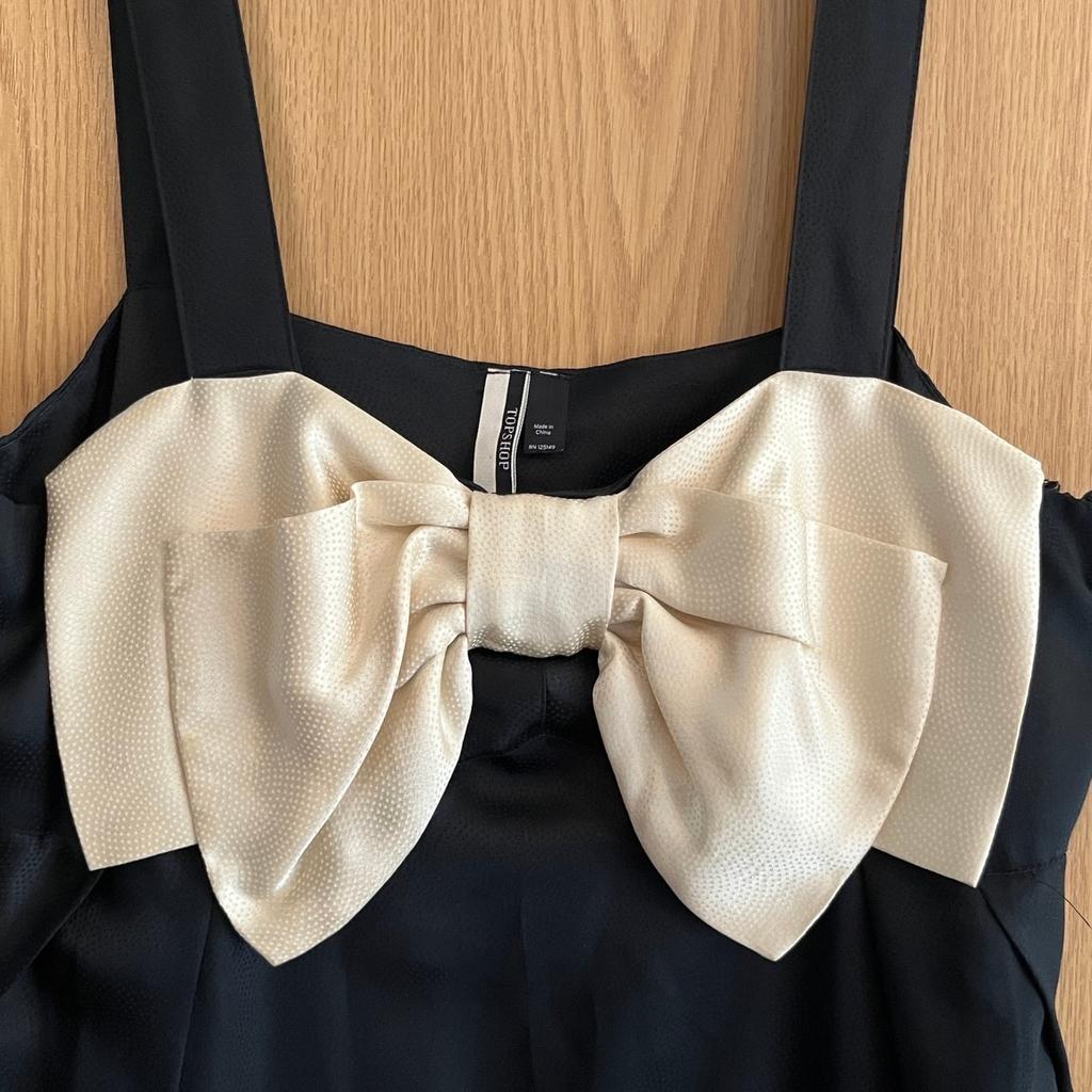 Beautiful vintage black evening dress with cream bow

100% silk

Slight pattern to silk as shown in pictures

TopShop Size 14 - fits a 12/14

Knee length

Worn twice - Like new

Zip fastening to side

Very comfortable and flattering