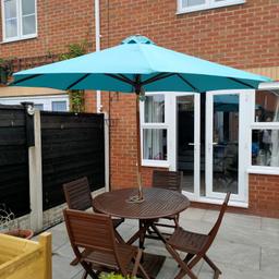 Round wooden table with 4 chairs, teal coloured 2.7m parasol with matching cushions. Also heavy parasol base available.
Has been painted up a few times and looks pretty good. There is a little damage to the chair legs but can be covered with a repaint. See photos.

Collection only. B65