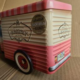 A pair of biscuit tins with a tuk tuk design.  Wheels spins & make a unique desk piece or display use.