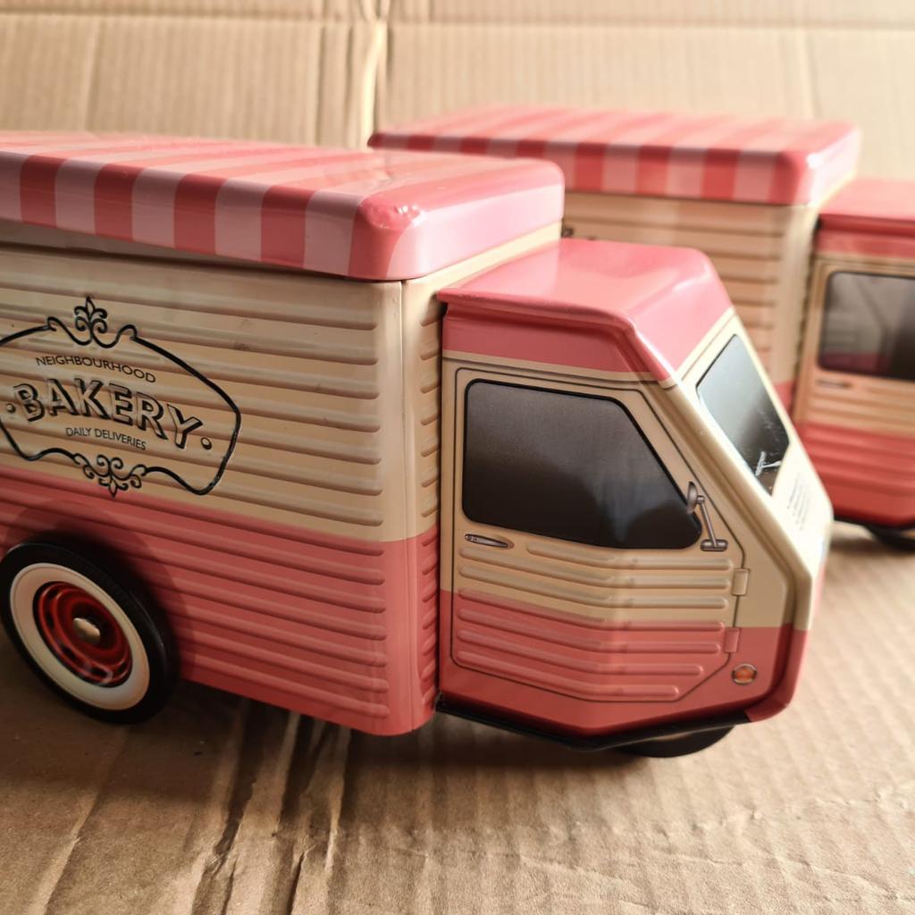 A pair of biscuit tins with a tuk tuk design. Wheels spins & make a unique desk piece or display use.