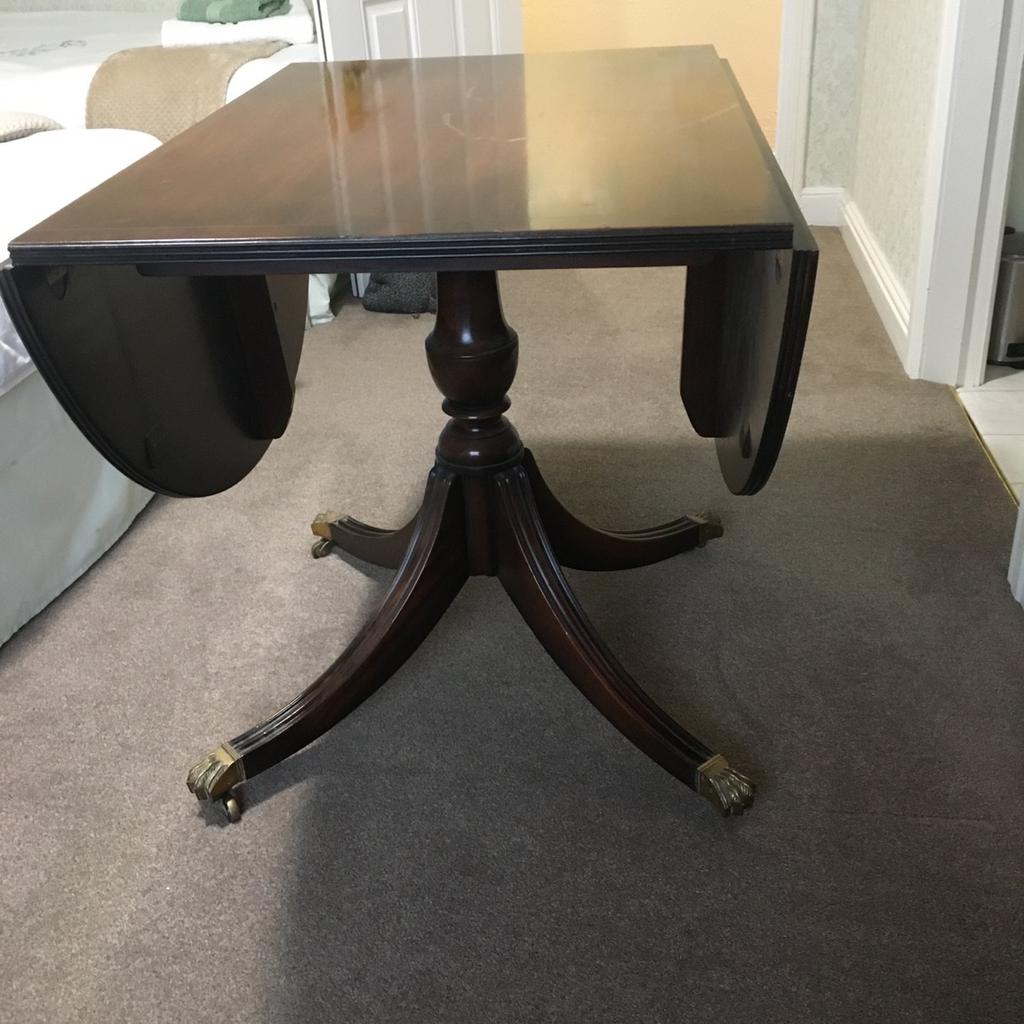 Oval mahogany dining table with tripod stand and brass casters , the top has 2 drop leaves, in fairly good condition apart from a scratch on the top , selling cheap to make space .