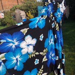 Gorgeous summer sundress. Fits up to a 14/16 it had a label on m/l. Beautiful on this asymmetrical hem dress has large blue florals on black background. It has a ruched elastic too so fits basically any size up to 16 . Stunning dress on for this hot spell