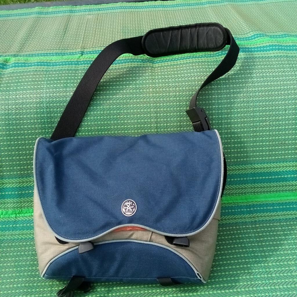 Crumpler Shoulder messenger bag.
Heavily padded to protect all tech kit, from phones to cameras.

Water resistant 1000D shell on 300D Ripstop lining, 3 x external pockets, 3 x internal front pockets, adjustable removable shoulder pad w/ Third Leg stability strap, adjustable main strap w/ Quick Flick TM buckle, clip & Velcro release flap, strap trap accessory loop. Converts to photo/video equipment bag with optional extras.

This has so many pockets, it will be like a TARDIS, as super comfortable & padded for reassurance.