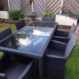 Black ratten Garden dinning set, comes with 6 chairs and cushions, 1 large dinning table sitting for 6 safety glass top,2 Black panels 1 clear, in excellent condition, smoke and pet free house, collection only cash only payment