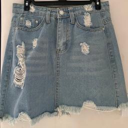 Light blue, ripped denim skirt. 2 decent size pockets front and back.