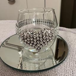 Very pretty eye catching tea light holder.heavy glass base at the bottom.shape of a ring going all way round heart feature.diamonte effect silver stones.new item