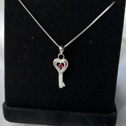 GIFT BOX NOT INCLUDED UNLESS BOUGHY SEPARATELY
 Sterling Silver stamped 925 beautiful key necklace
Dark pink gemstone in middle 
Key also stamped as pictured 
£5 with certificate of authenticity comes in packaging or £7 with black velvet gift box 

🎄perfect little stocking filler🎄