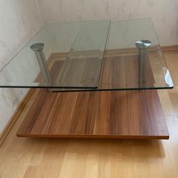 Glastisch mit schwenkbaren Glasplatten.