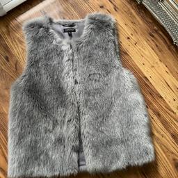 Like new grey fur gillet with two side pockets looks wonderful on.
