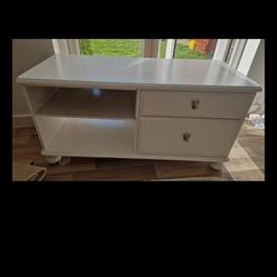 White TV unit in good condition. 2 drawers, 2 open shelves. Delivery will be considered within 3 mile radius if purchase confirmed. Outside dimensions are L: 110cms x W: 42cms x H: 55cms