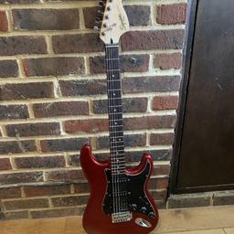 Squier Stratocaster in red. Humbucker at the bridge. Sounds and plays fantastic. Some cosmetic damage to paint work that has since been touch in. Brilliant gigging guitar or backup. No gig bag or strap included. 