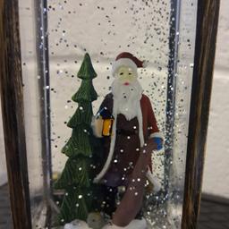 Christmas ornament. In very good condition.Battery operated, illuminated light, with a figurine statue of santa in liquid and tinsel flakes. More details can be seen in photos.