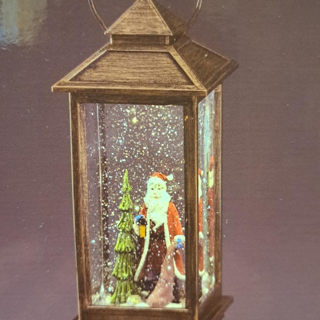 Christmas ornament. In very good condition.Battery operated, illuminated light, with a figurine statue of santa in liquid and tinsel flakes. More details can be seen in photos.