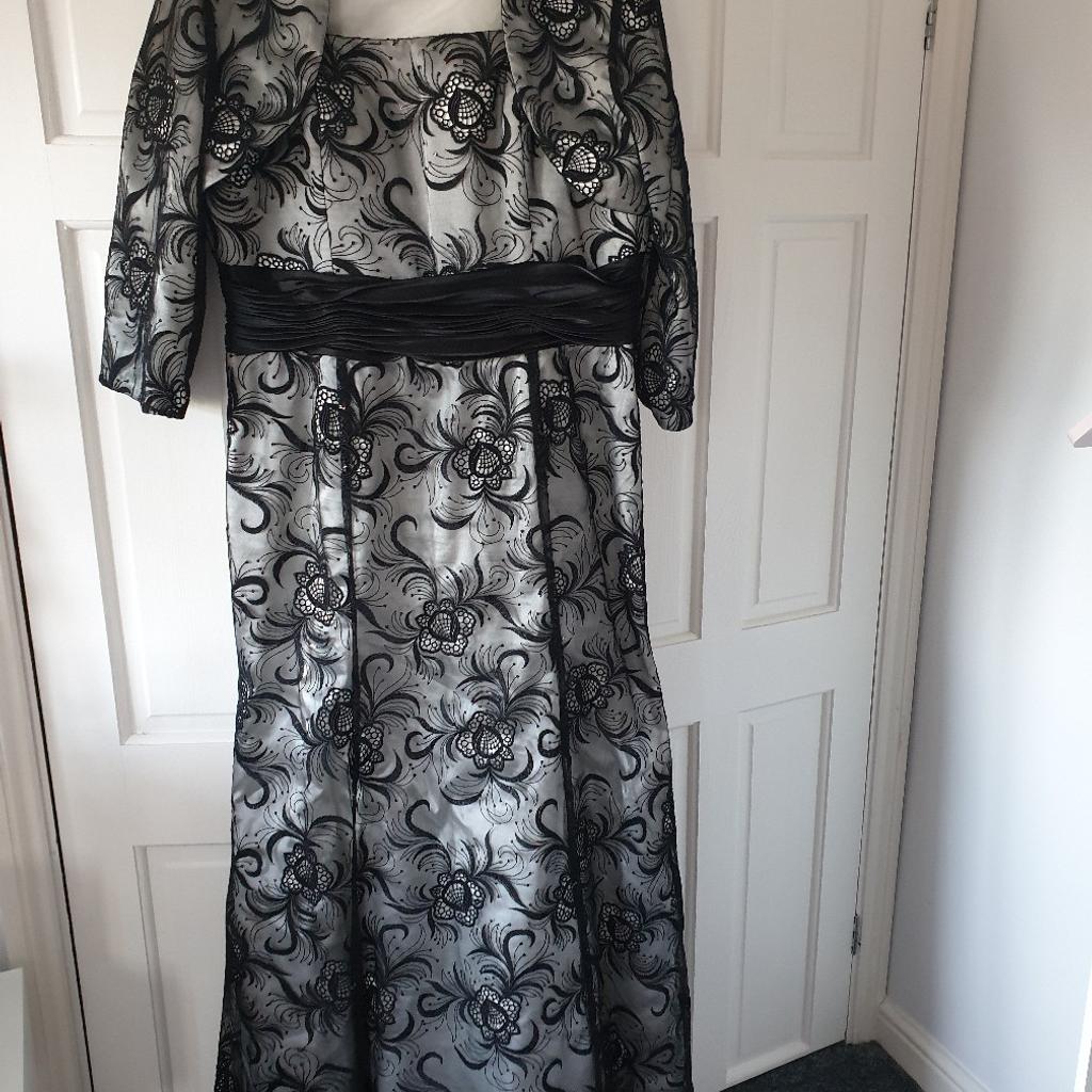A gorgeous 2 piece black lace maxi dress with floral patterns & delicate sequins scattered all over. Has a matching pretty lace jacket. A UK Size 16 but can fit size 18 too as the back is adjustable with extra space & material and ribbon ties. The dress was purchased from a boutique in Hertfordshire by Dynasty London. The dress hem has a delicate fishtail design & falls beautifully with a slimming shape.

Rarely worn so in excellent condition.

For collection or can be posted.

Good offers will be considered.