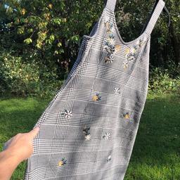 New Topshop pinafore dress. New with label attached £32 . Lovely and cosy item looks great with jumper and boots. Check with pretty embroidered florals to front. Has a bit of stretch too. Great dress.