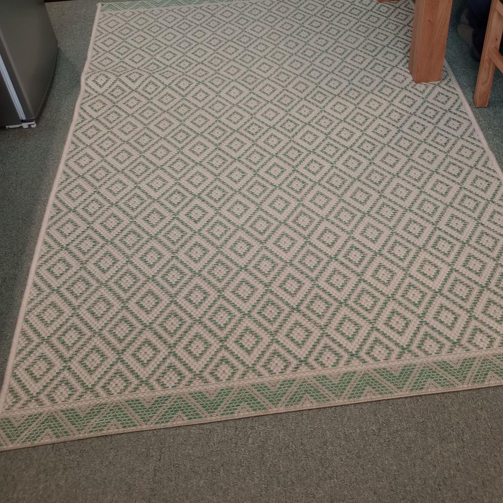 This is a really nice Rug which can be used in any room. The size is 6 1/2 ft x 4 1/2ft or 80inch x 56inch. in a Green and Beige colour.