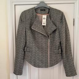 Grey jacket with mettalic thread sparkle.hangs longer at the front zip fastening.buckle detail at the sides.fully lined inside.size 12.from Miss Selfridges.new with tags on Been £45.00