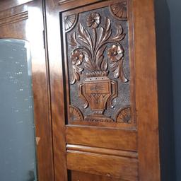 vintage wardrobe with wooden carvings on either side of mirror. originally al bone handles.