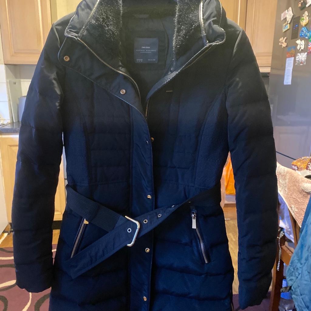 Lovely warm padded stylish women’s zara 3/4 length winter coat with front full zip and side bottom zips also popper buttons with belt and 2 zip side pockets and material design sides and fur trim around the collar. Size small Pick up only.