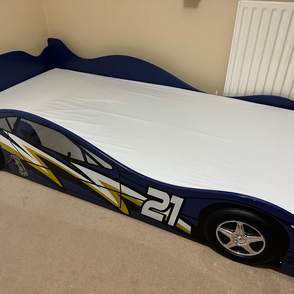 IN VERY GOOD CONDITION and only a little scratch which really can’t be seen.

A modern and well-designed No. 21 car bed, with the look of a real racing car, which was ideal for my son who loved cars!

High side rails and high back-end allowed my son to sleep safely; protection from falling off the bed during sleep.

Purchased mattress separately for £120 which was made-to-order so size of 10cm so that child can not fall.
Always used separate fitted sheet then a waterproof mattress protector underneath so there’s no soiling and the mattress is as brand new!

Sturdy – Made from tough MDF with a supportive slatted base; bed built to last.
Fun – Great for young fans of cars and racing, this bed will appeal to budding young racers.

Colour: Blue
Made of MDF wood
Graffiti numbers and letters
Takes a standard 3ft single mattress WHICH I AM SELLING WITH THE BED
Slatted base
Dimensions: H 52 x W 99.6 x L 203.5cm

Smoke free and pet free home

Cash on collection please!