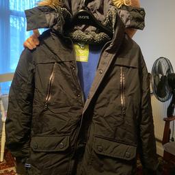 Boys winter coat, with blue fleece lining, fitted fur trim hood, zip up and popper buttons pockets and side access of pockets to keep hands warm while wearing.