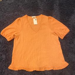 Ladies v neck top
Short sleeves with elastic 
Material is crinkle type and stretchy 
Frill to bottom
New with tags
Terracotta colour