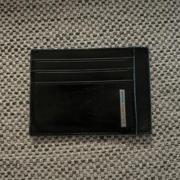Presenting this Piquadro Blue Square card wallet, a classic addition to any men's accessories collection. The wallet features a solid pattern and is made of high-quality leather. It is designed to hold up to 6 credit cards and has ample space for notes. The wallet also comes with an accent logo and has dimensions of 11 x 8 x 0.5 cm.

This Blue Square wallet is perfect for those who appreciate vintage design with a modern twist. It is suitable for everyday use and is a must-have for those who prefer a slim and compact wallet that fits comfortably in their pocket. Get this Piquadro wallet today and add a touch of sophistication to your everyday style.