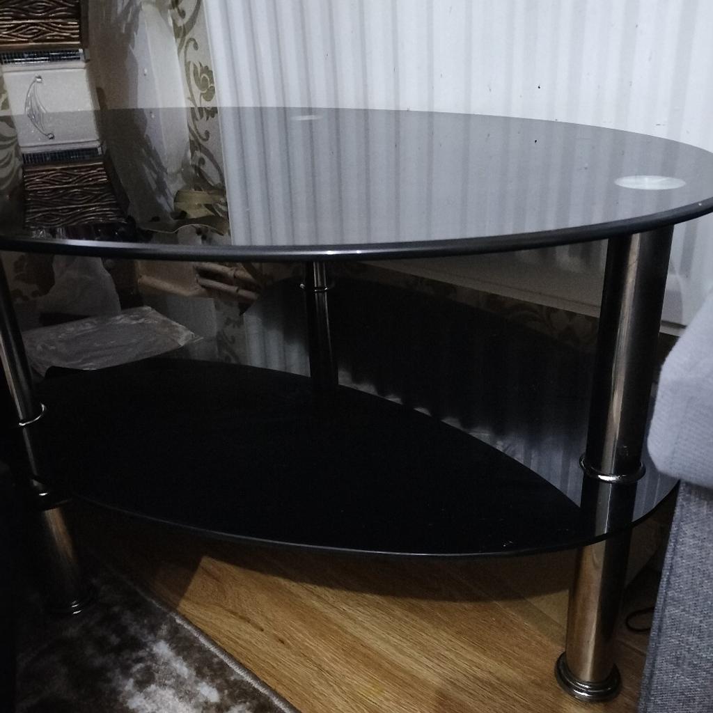 black glass coffee table. 2 tiered. in good condition with a few unnoticeable and faint scratches. 97cm length and 57cm width. one joint has come off but can easily be fixed with glue